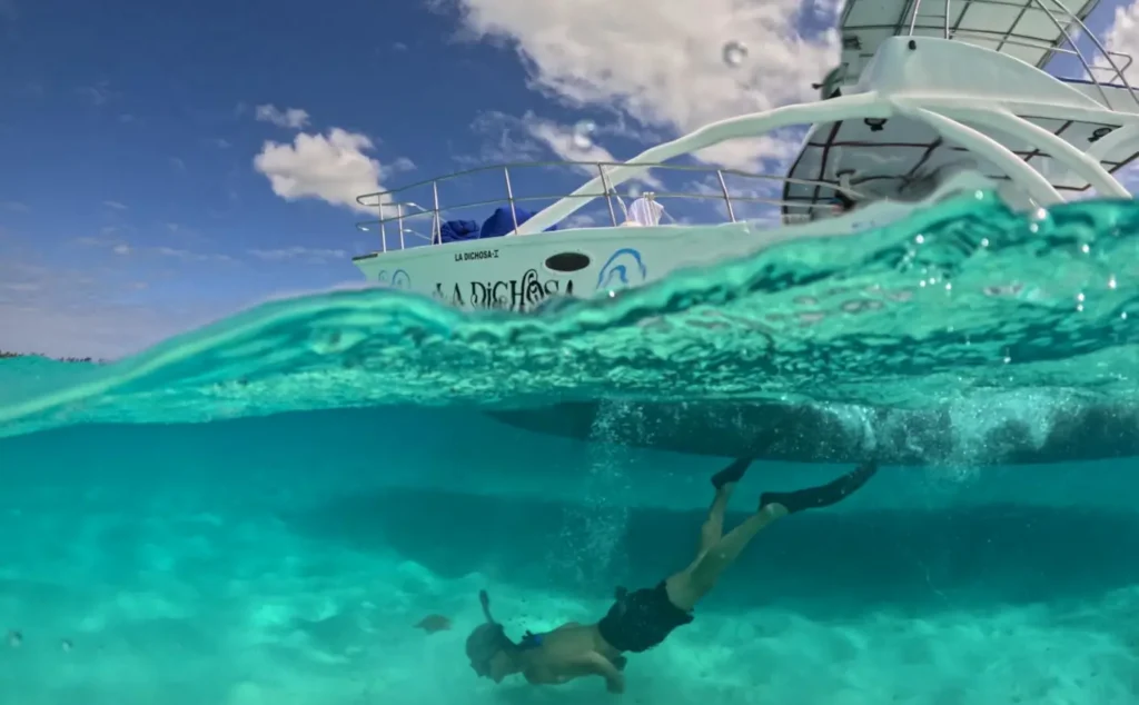 Guests snorkeling beside La Dichosa during a private Saona Island charter
